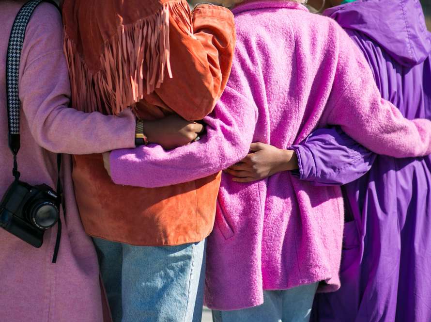 group of women supporting each other by embracing in a line